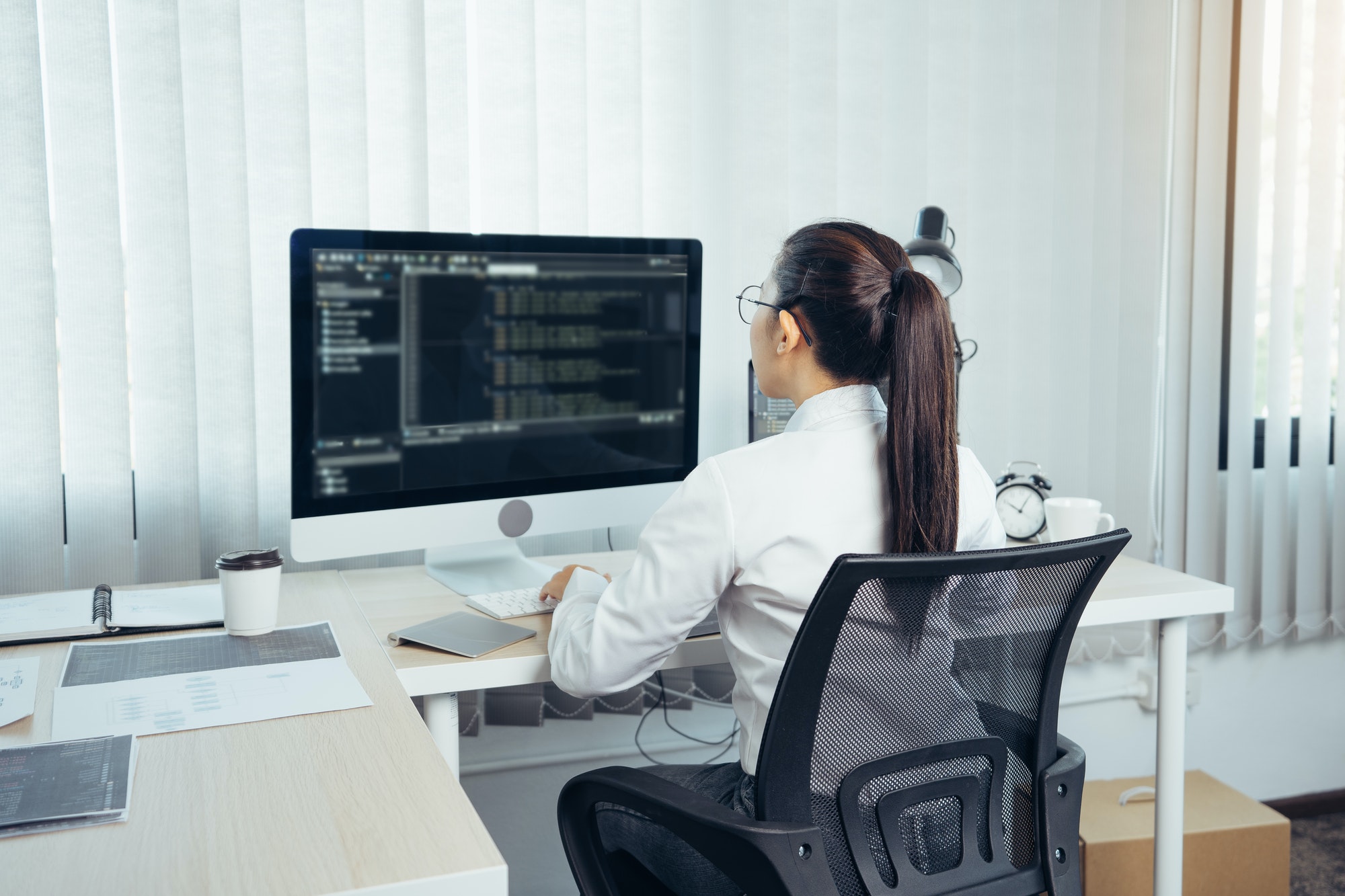 Asian woman professional development programming website working a software in office room.